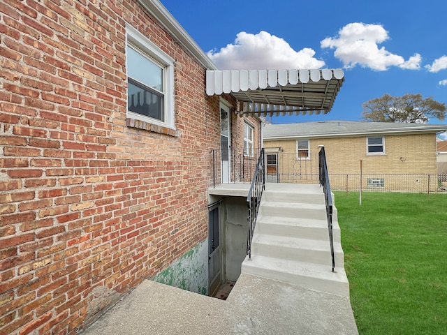 view of exterior entry with a yard