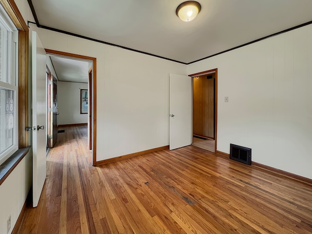 empty room featuring hardwood / wood-style floors and ornamental molding