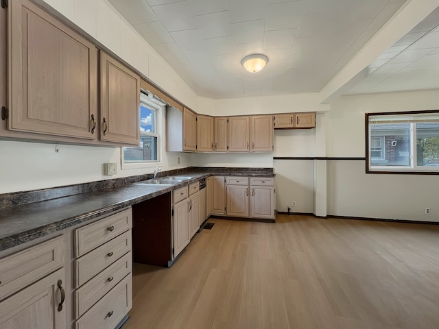 kitchen featuring light brown cabinets, dark stone countertops, sink, and light hardwood / wood-style flooring