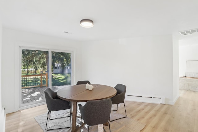 dining room featuring light wood-type flooring and baseboard heating