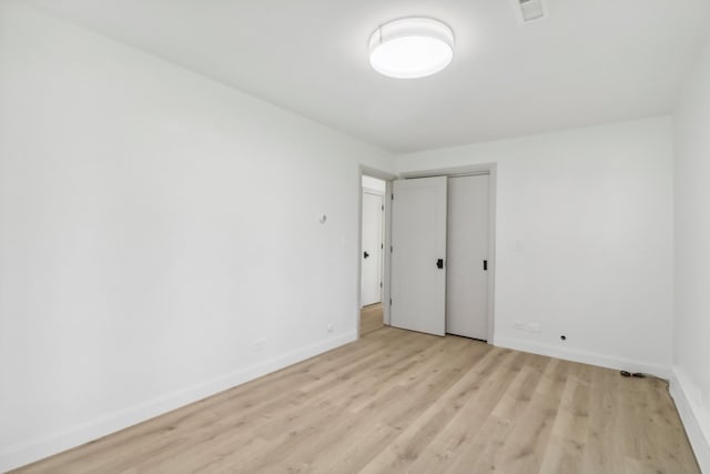 unfurnished bedroom featuring light wood-type flooring and a closet