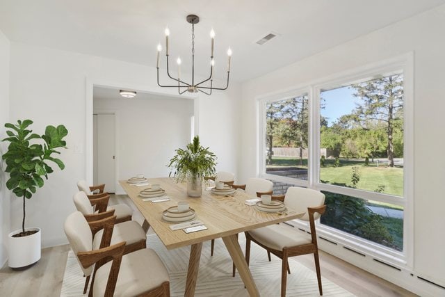 dining space with a notable chandelier and light hardwood / wood-style floors