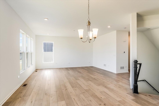 interior space featuring light wood finished floors, visible vents, and an inviting chandelier