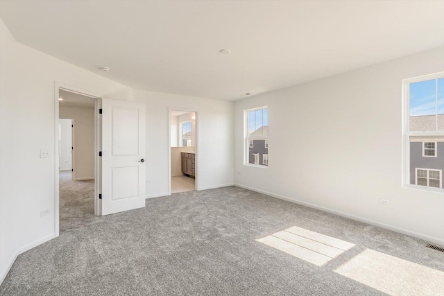 carpeted spare room featuring baseboards