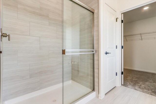 bathroom featuring vanity, wood-type flooring, and a shower with shower door