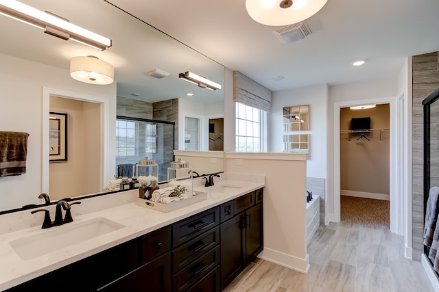 bathroom with vanity and shower with separate bathtub