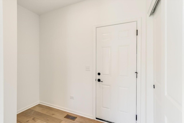 interior space with light wood-type flooring, visible vents, and baseboards