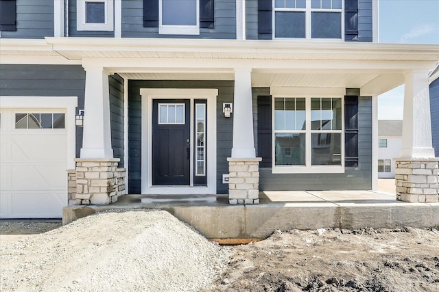 entrance to property with covered porch and stone siding