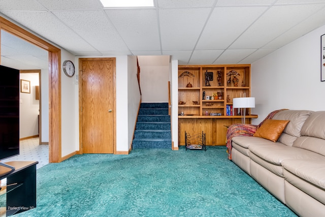 living room with a drop ceiling and carpet floors