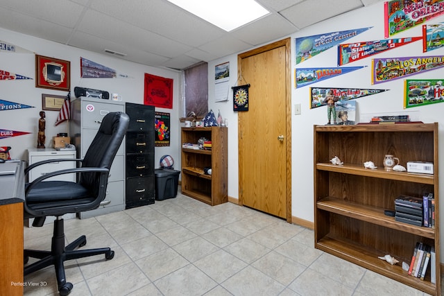 tiled office space with a paneled ceiling