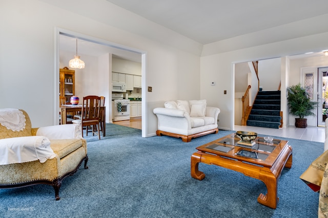 carpeted living room featuring a notable chandelier