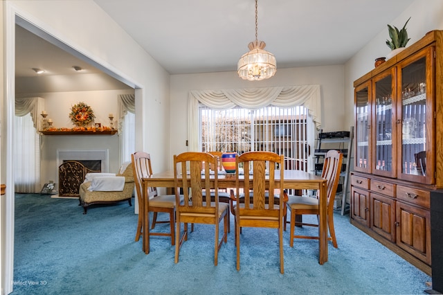 carpeted dining area with an inviting chandelier