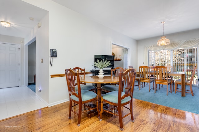 dining area featuring a notable chandelier and light wood-type flooring