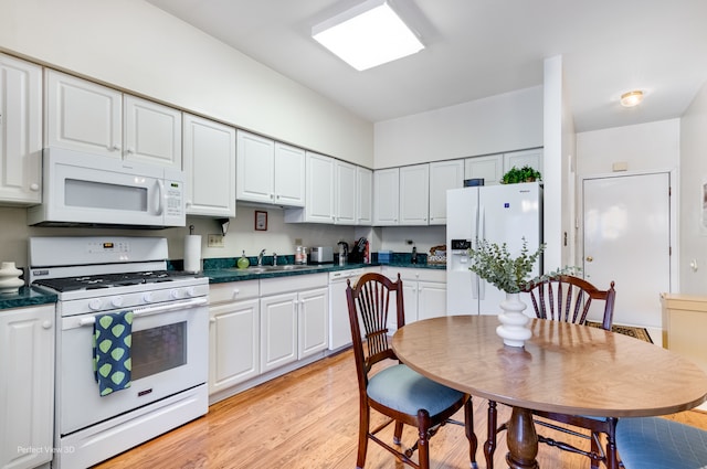 kitchen with white appliances, white cabinetry, light hardwood / wood-style flooring, and sink