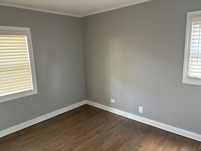 spare room with dark hardwood / wood-style flooring, a wealth of natural light, and ornamental molding