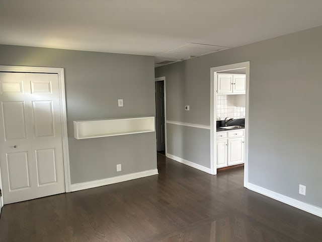 empty room with sink and dark wood-type flooring