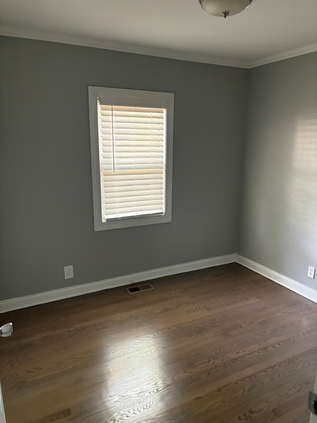 spare room featuring dark hardwood / wood-style floors and ornamental molding