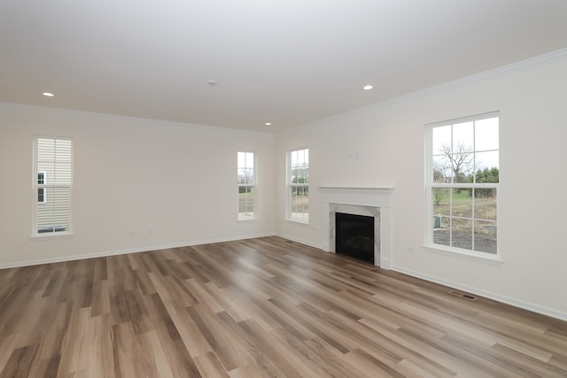 unfurnished living room with light hardwood / wood-style flooring and crown molding