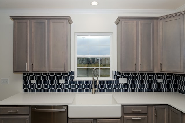 kitchen featuring backsplash, crown molding, sink, and stainless steel dishwasher