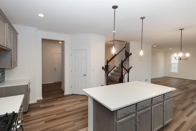 kitchen with a center island, dark hardwood / wood-style flooring, stove, decorative light fixtures, and gray cabinets