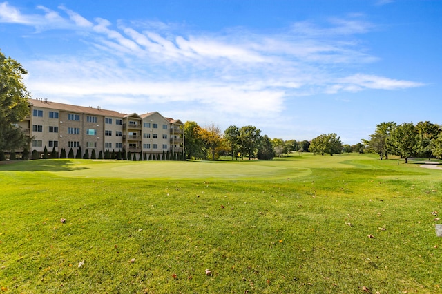 view of property's community featuring a yard and view of golf course