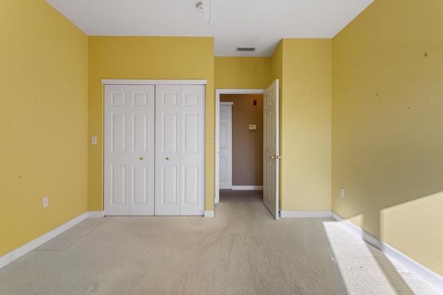 unfurnished bedroom featuring a closet, visible vents, baseboards, and carpet floors
