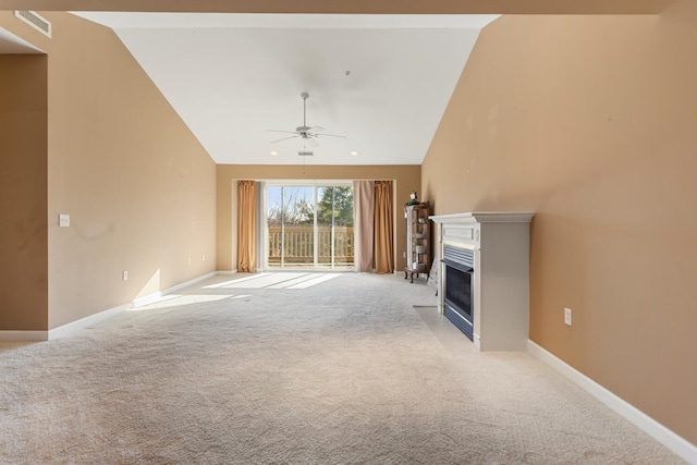 unfurnished living room featuring a glass covered fireplace, baseboards, a ceiling fan, high vaulted ceiling, and light colored carpet