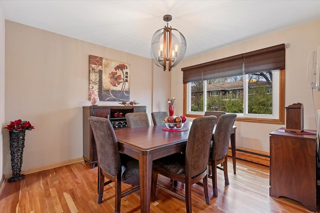 dining space featuring a notable chandelier, light wood-type flooring, and a baseboard heating unit