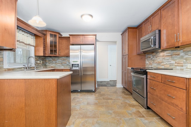 kitchen featuring backsplash, pendant lighting, stainless steel appliances, and sink