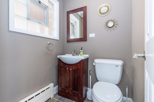 bathroom with tile patterned floors, vanity, toilet, and baseboard heating