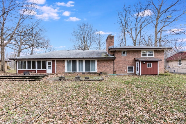 back of property with a lawn and a sunroom