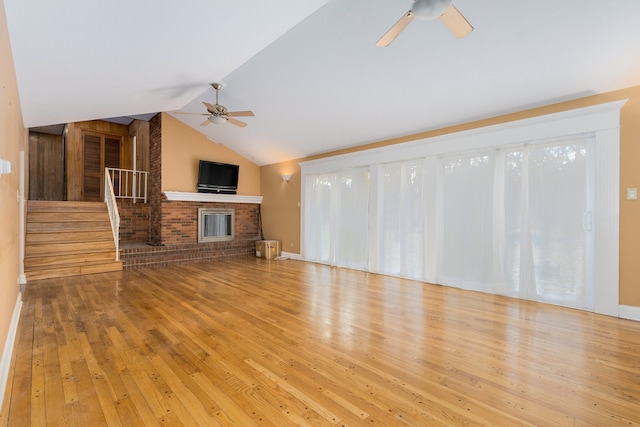 unfurnished living room with a brick fireplace, vaulted ceiling, light hardwood / wood-style flooring, and ceiling fan