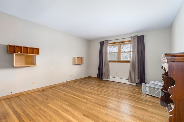 unfurnished living room featuring baseboard heating and light hardwood / wood-style flooring