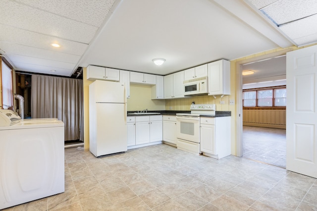 kitchen with white appliances, white cabinetry, a baseboard heating unit, and sink