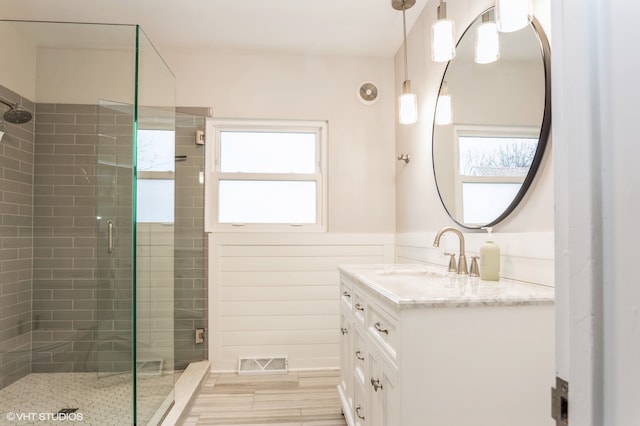 bathroom featuring hardwood / wood-style floors, vanity, and a shower with shower door