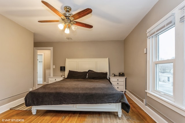 bedroom featuring multiple windows, ceiling fan, and light wood-type flooring