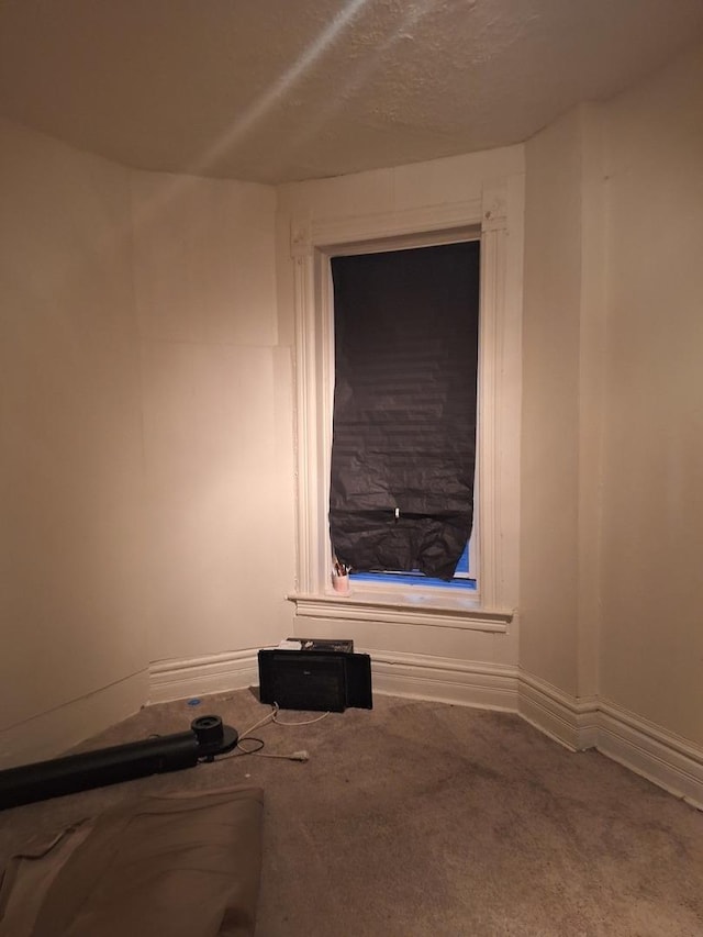 unfurnished room featuring carpet floors and a textured ceiling