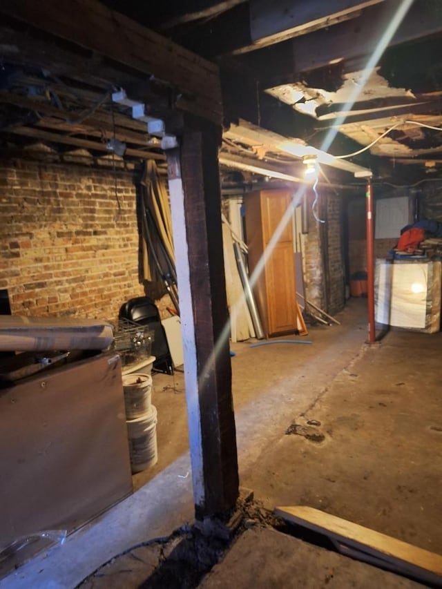 basement featuring brick wall