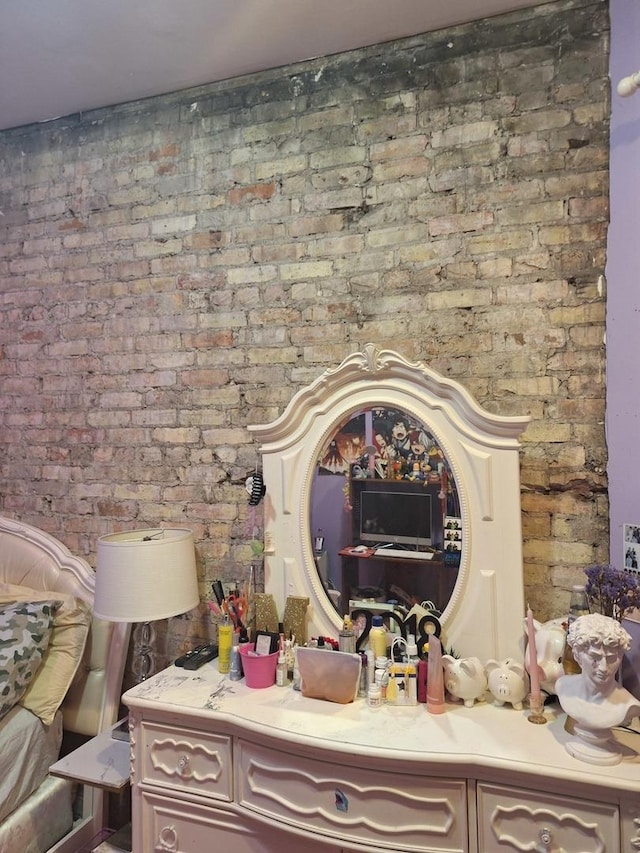 bathroom featuring vanity and brick wall