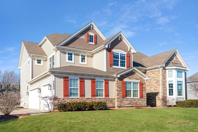 view of front of house with stone siding, roof with shingles, concrete driveway, a front yard, and a garage