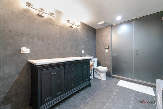 bathroom with toilet, vanity, recessed lighting, tile patterned floors, and tile walls