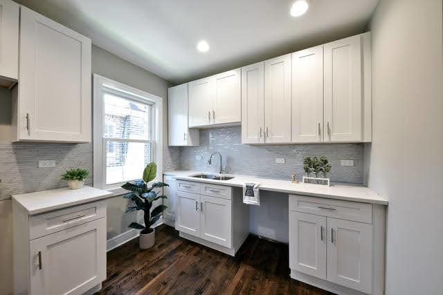 kitchen featuring backsplash, sink, white cabinets, and dark hardwood / wood-style floors