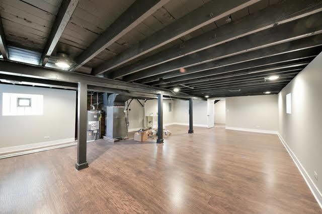 basement with hardwood / wood-style floors, gas water heater, and heating unit