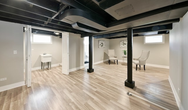 basement with light wood-type flooring and a wealth of natural light