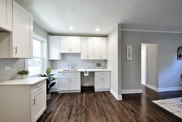 kitchen with white cabinetry, sink, crown molding, and dark hardwood / wood-style floors