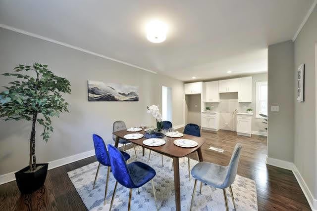 dining space featuring dark hardwood / wood-style flooring and crown molding