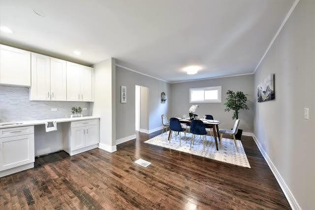 dining room featuring ornamental molding and dark wood-type flooring