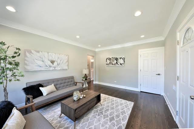 living room featuring dark hardwood / wood-style floors and crown molding