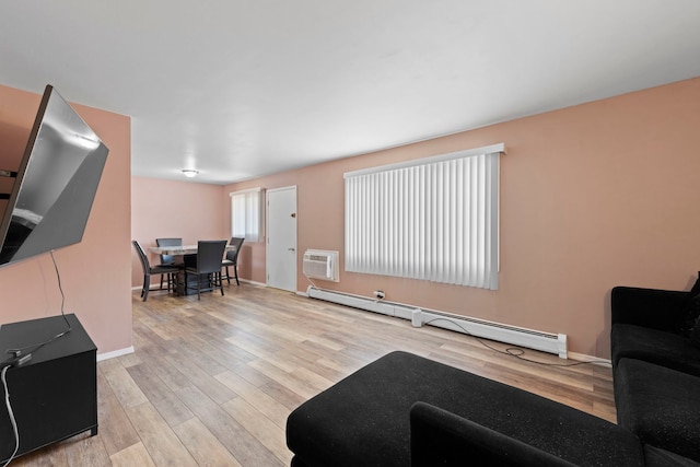 living room with light wood-type flooring, a wall unit AC, and baseboard heating