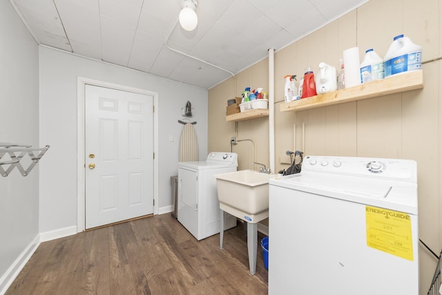 laundry room with dark hardwood / wood-style flooring, independent washer and dryer, and sink